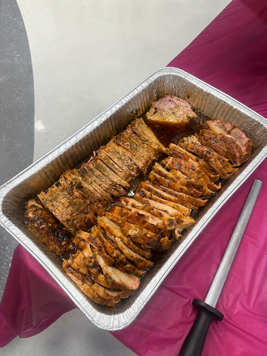 Sliced pork tenderloin arranged in a catering tray
